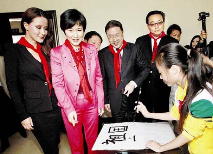 中国电力国际有限公司董事长、首席执行官李小琳在家乡高县‚一身桃红色套装‚喜气洋洋。