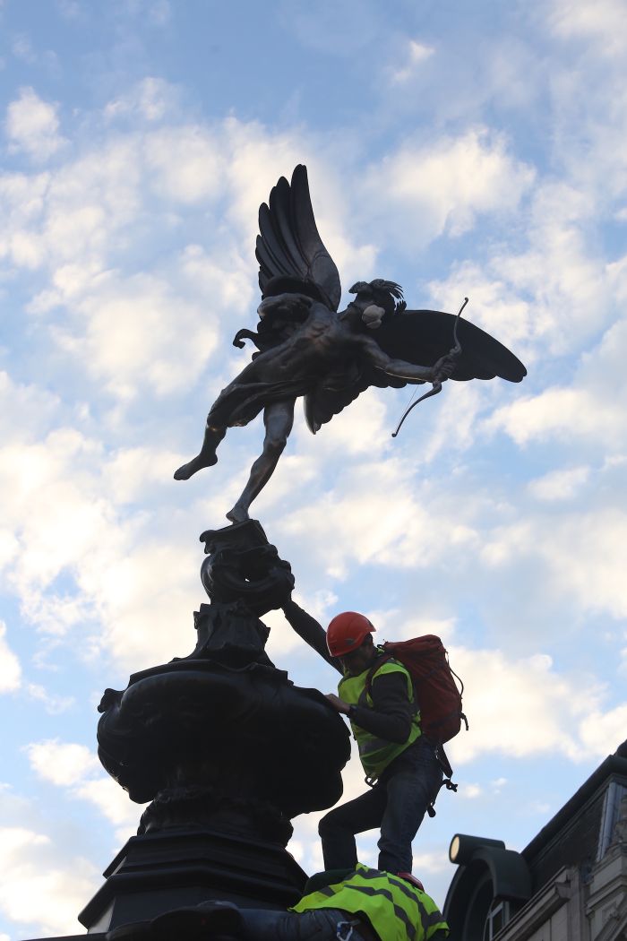 Greenpeace activists climb Eros to fit the statue with an emergency face mask (photo © John Cobb / Greenpeace)