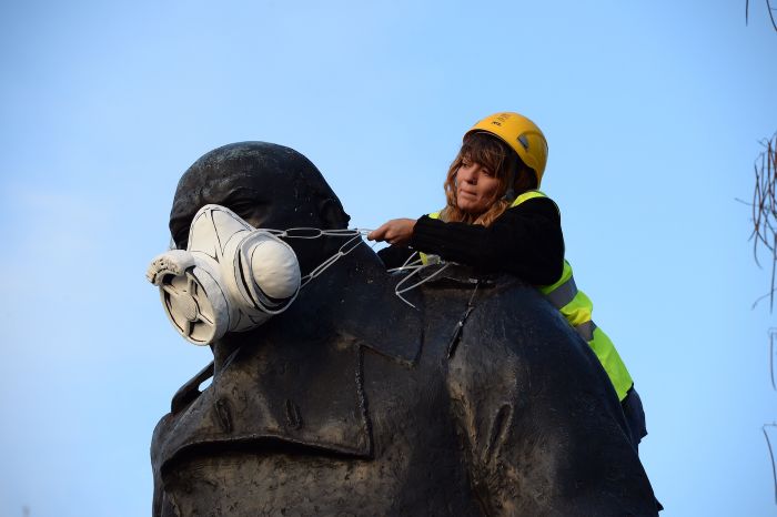 A Greenpeace activist fits the statue of Churchill at Parliament Square with an emergency face mask (photo © Chris Ratcliffe / Greenpeace)