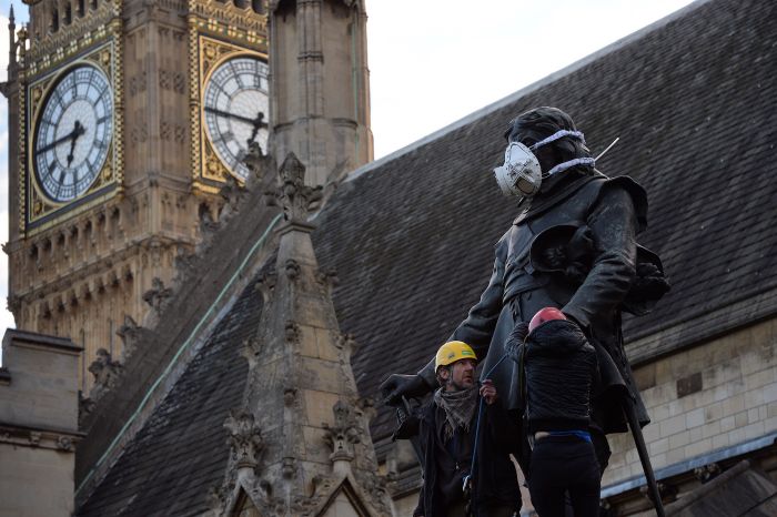 Greenpeace activists fit the Oliver Cromwell’s statue with an emergency face mask to demand action on air pollution (photo © Chris Ratcliffe / Greenpeace)