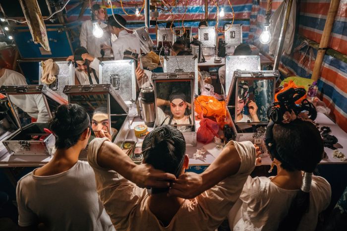Performances of Chinese opera are usually held in a mat-shed at the Pak Tai Temple in Taipa village. In this small temporary make-up room built solely with bamboo and iconic red-blue-white plastic bags, over 10 performers are preparing for the show.
